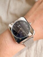 Reloj QYQ unisex en malla plateado fondo azul